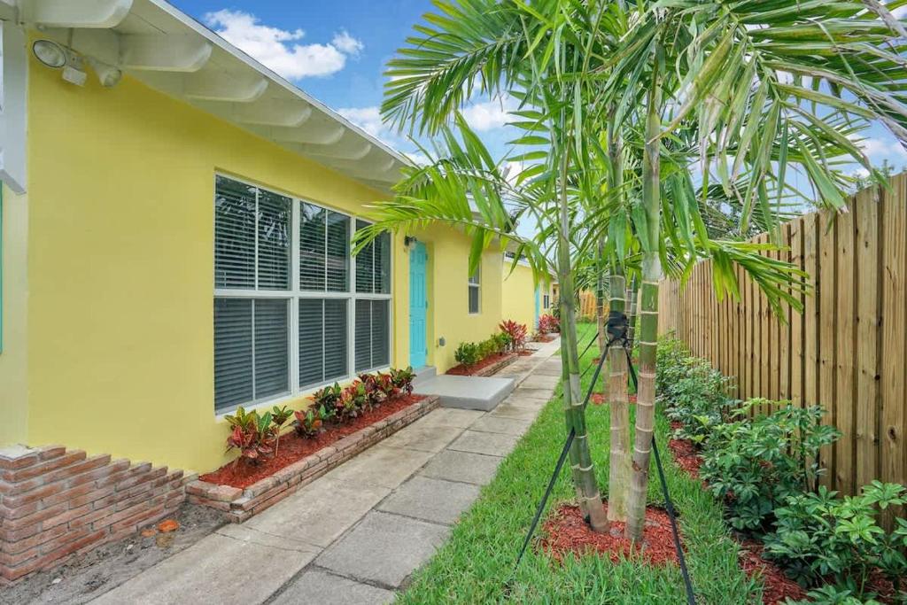 a yellow house with a palm tree in front of it at Beach Getaway One Block from the Beach in Pompano Beach