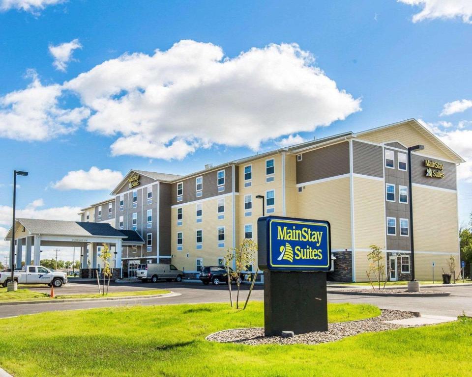 un cartello di fronte a un edificio con un hotel di MainStay Suites Sidney - Medical Center a Sidney