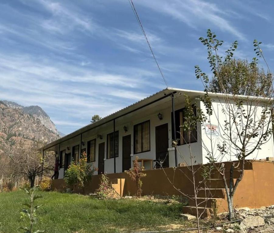 a small house with a mountain in the background at Yashraj Cottages in Jari
