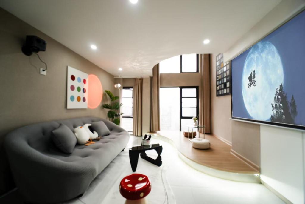 a living room with a couch and a large tv at Qixin Homestay in Changsha