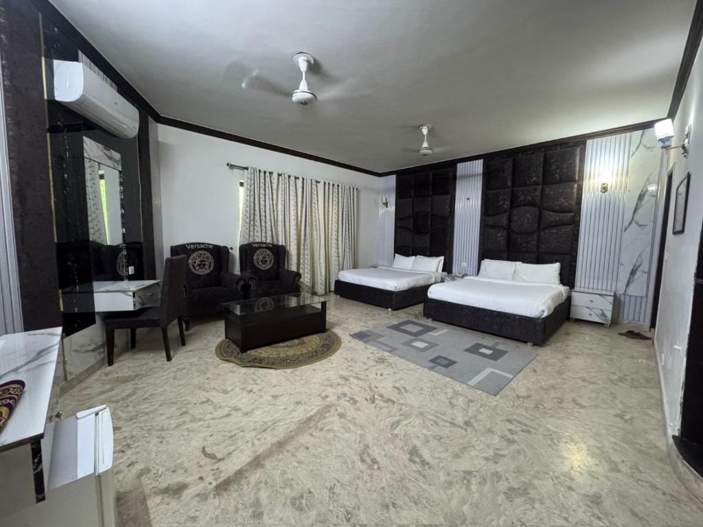 ein Hotelzimmer mit zwei Betten und einem Schreibtisch in der Unterkunft Bridge Residency F6 Islamabad in Islamabad