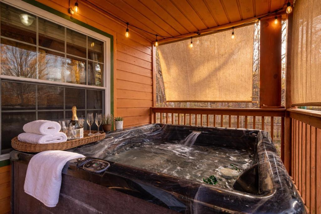 a large black tub in a room with a window at One Level, Pet Friendly, Huge Fenced in Yard, Views, EasyRoads, Pool Table, Spa, Theater, Outdoor fun in Sevierville