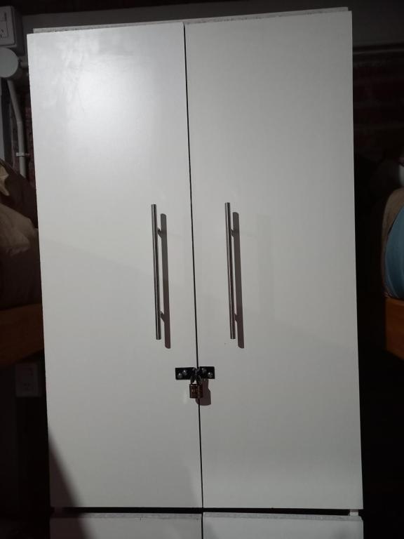 een witte kast met twee deuren in een kamer bij Hostel El Duende Errante in El Bolsón
