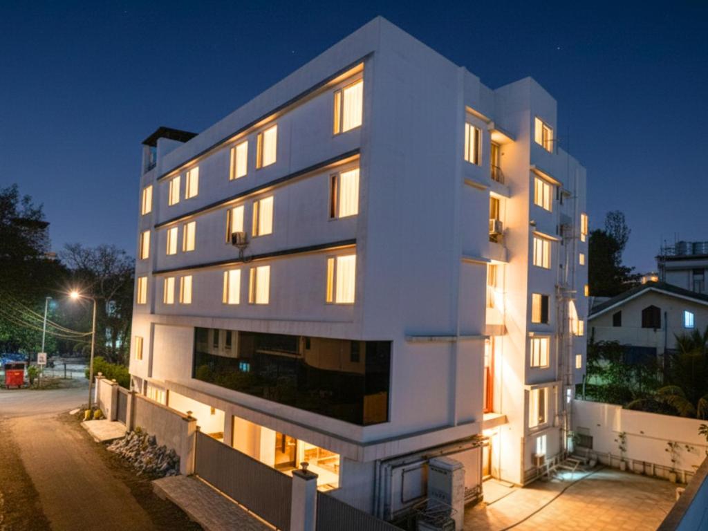 een wit gebouw met verlichte ramen 's nachts bij Samrat Studios in Pune