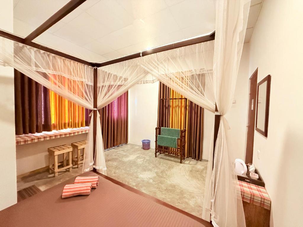une chambre avec un lit à baldaquin dans une pièce dans l'établissement Coconut Reach, à Mirissa