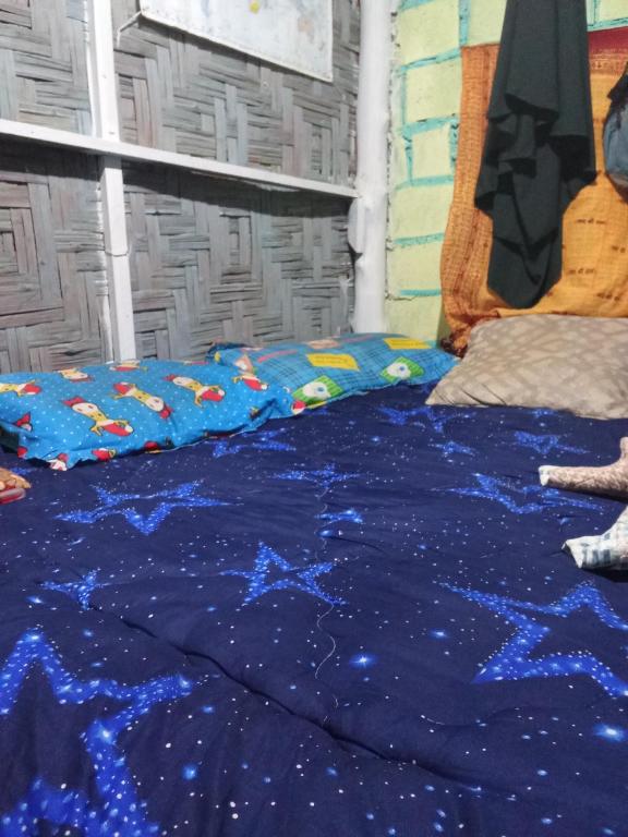 a bed with a blue blanket on top of it at Easy Life Hut in Ko Bu Bu