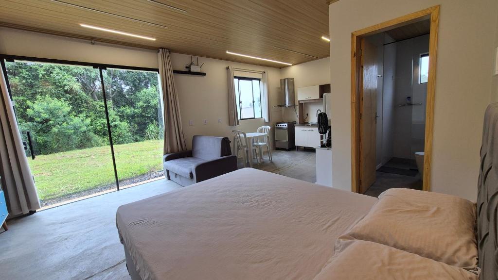 VideiraApartamento Loft Terreo的一间卧室配有一张床,享有厨房的景色