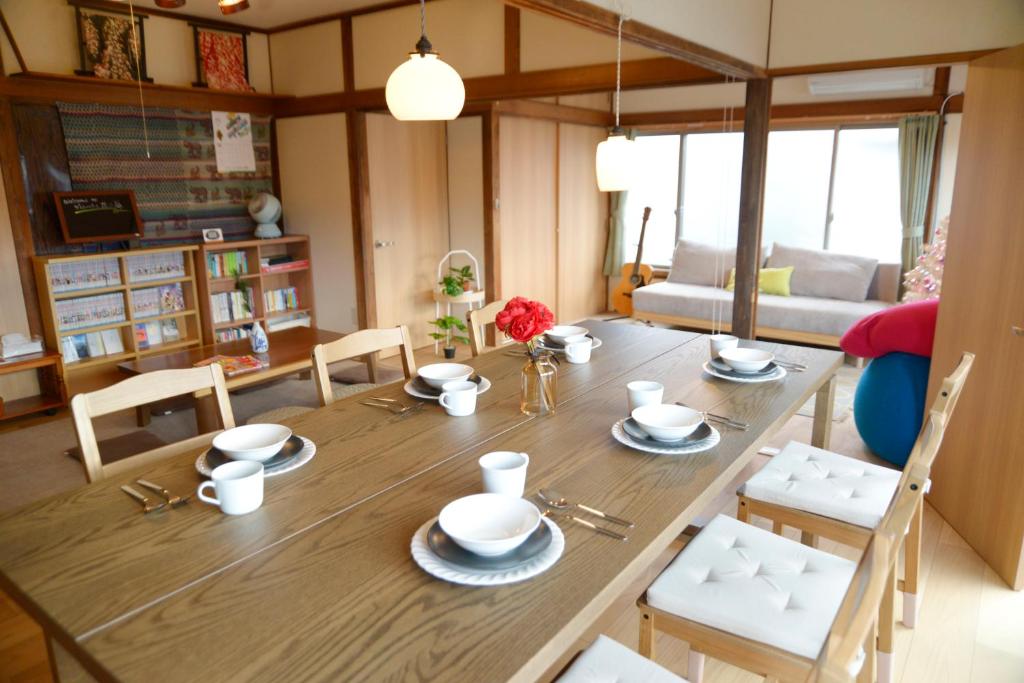 een eetkamer met een houten tafel en stoelen bij 宇都宮ゲストハウス花ニ嵐 in Utsunomiya