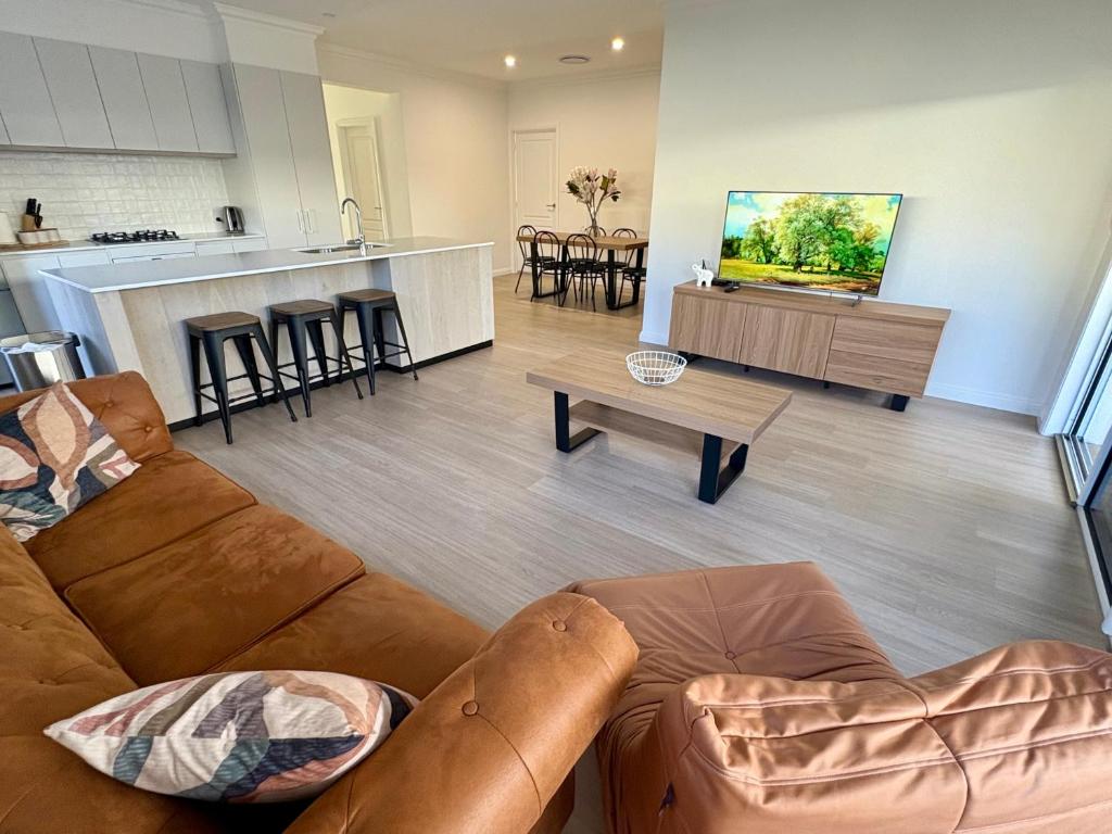 a living room with a couch and a kitchen at Spring Haven in Wagga Wagga