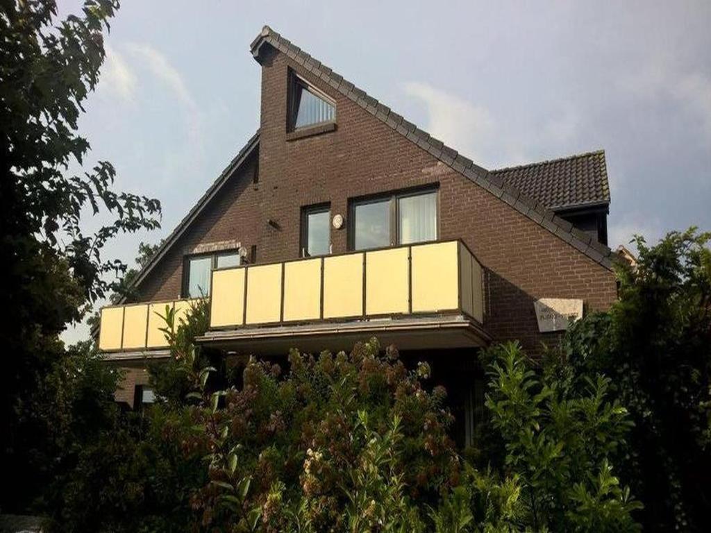 ein Backsteinhaus mit Balkon darüber in der Unterkunft Gästehaus Vogel in Horumersiel