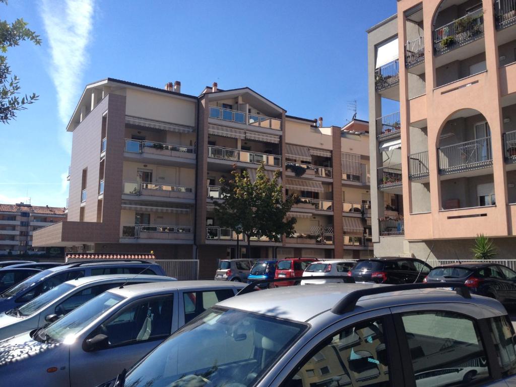 un parking avec des voitures garées devant un bâtiment dans l'établissement Residenza D'Agnese, à Montesilvano