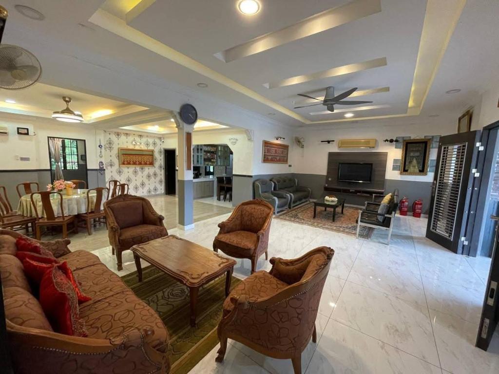 ein Wohnzimmer mit Sofa, Stühlen und einem Tisch in der Unterkunft Idid homestay in Kota Belud