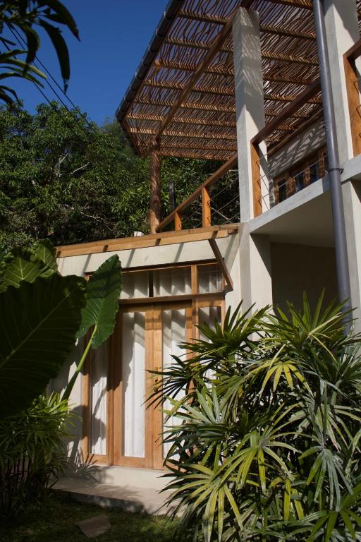 a facade of a house with trees in the background at Dannys Madiha in Kamburugamuwa