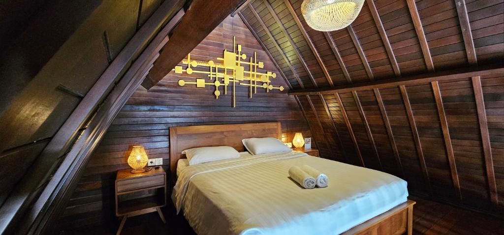 une chambre avec un lit et un lustre dans l'établissement Naturela, à Uluwatu