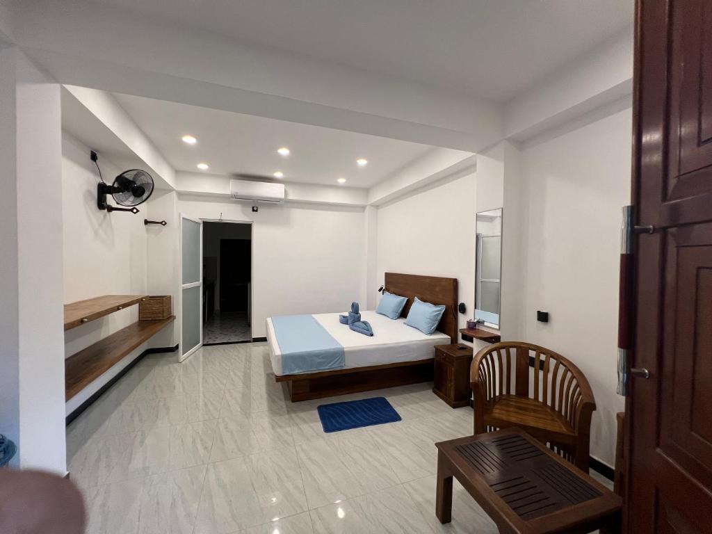 a bedroom with a bed and a table and a chair at Blue Mind Surf Home in Weligama