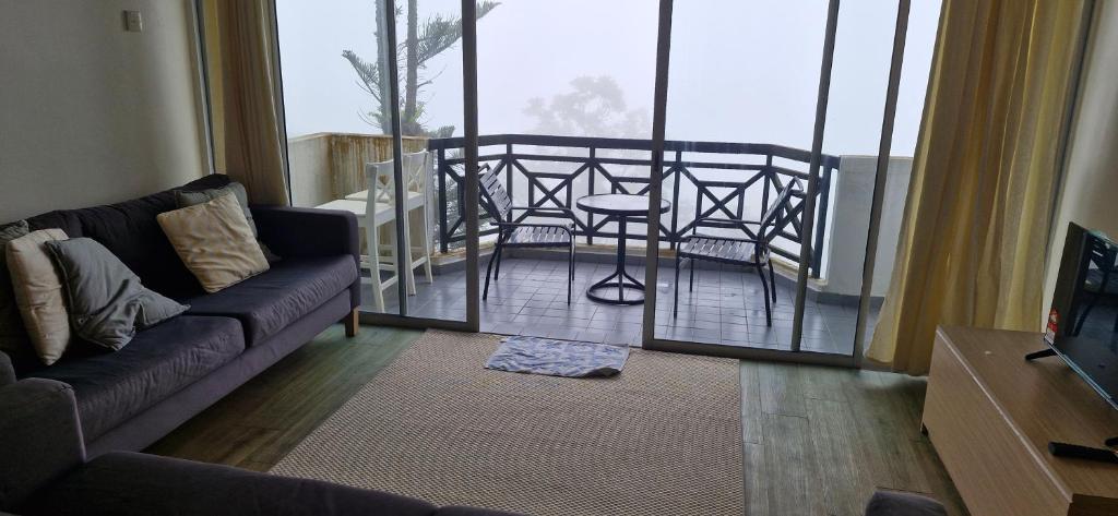 a living room with a couch and a balcony at B43A1 Silverpark 4th floor Best Mountain view in Bukit Fraser