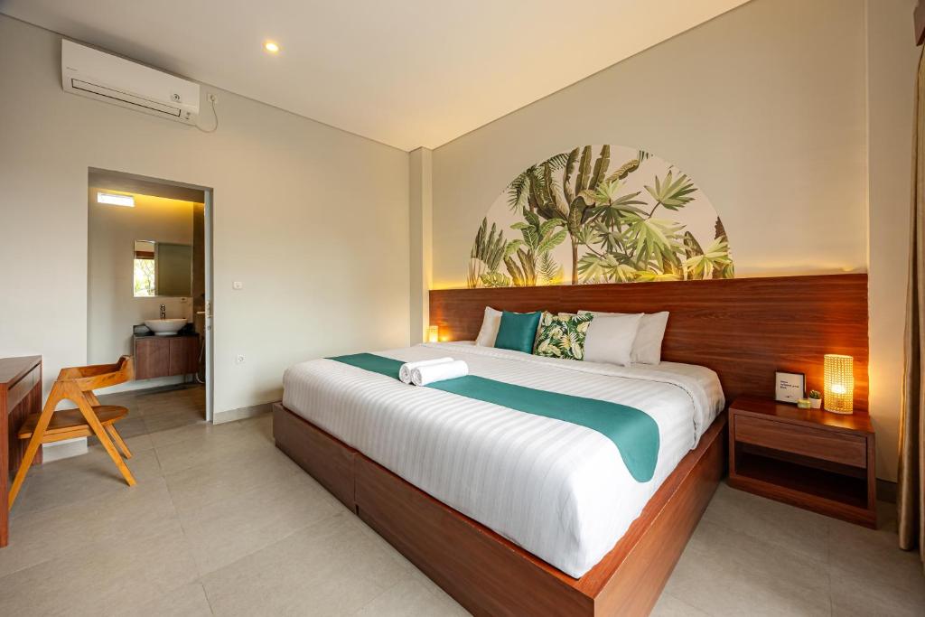 a bedroom with a large bed and a desk at Cove Puspa Canggu in Canggu