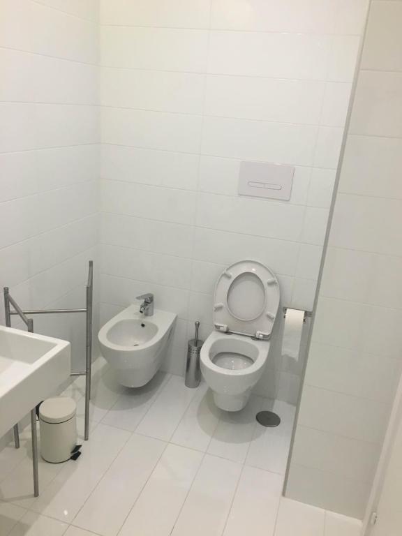 a white bathroom with a toilet and a sink at Casa Maria in Salerno
