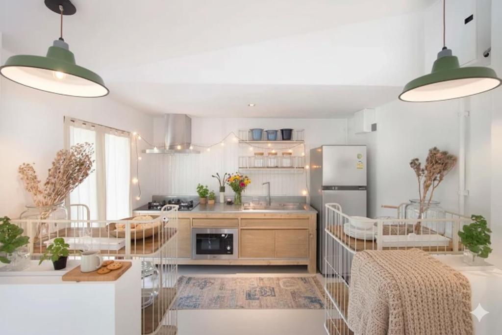 une cuisine avec des murs blancs et des appareils en acier inoxydable dans l'établissement Real Rare Resort, à Ban Laem Phak Bia (1)