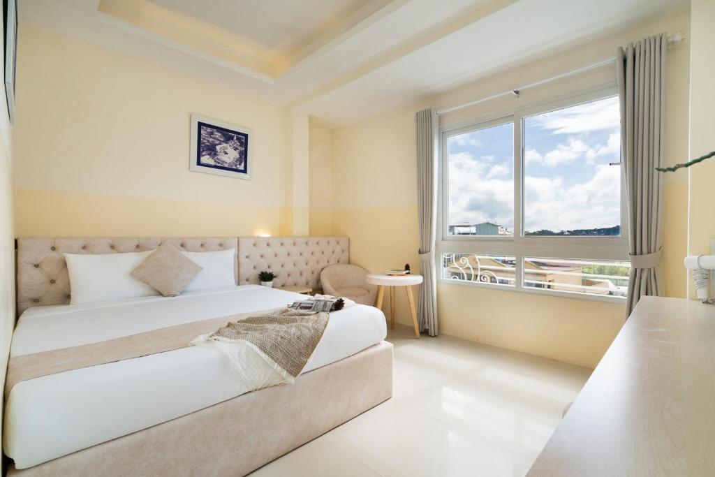 a bedroom with a bed and a large window at Ngoc Nguyen Anh Hotel Da Lat in Da Lat