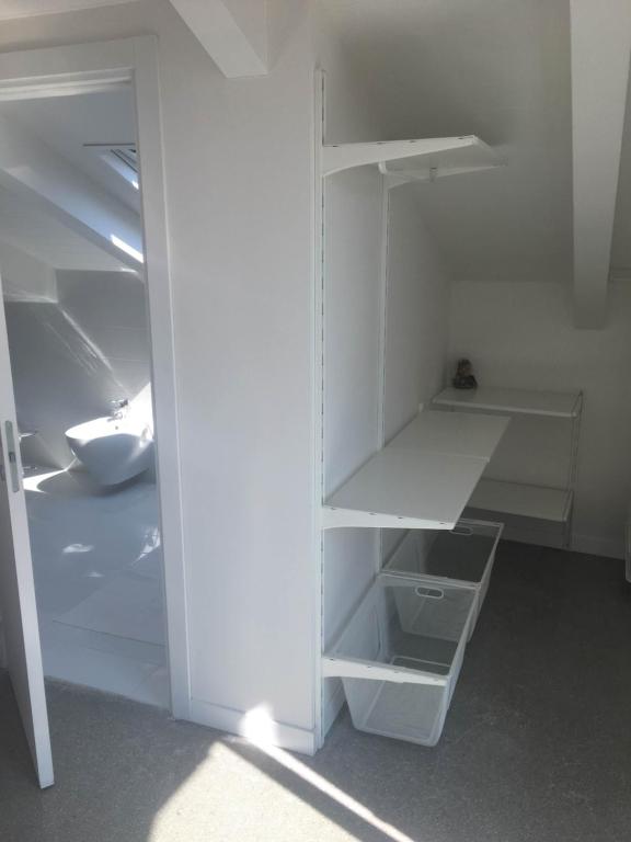 a white closet with empty shelves in a room at Casa Maria in Salerno
