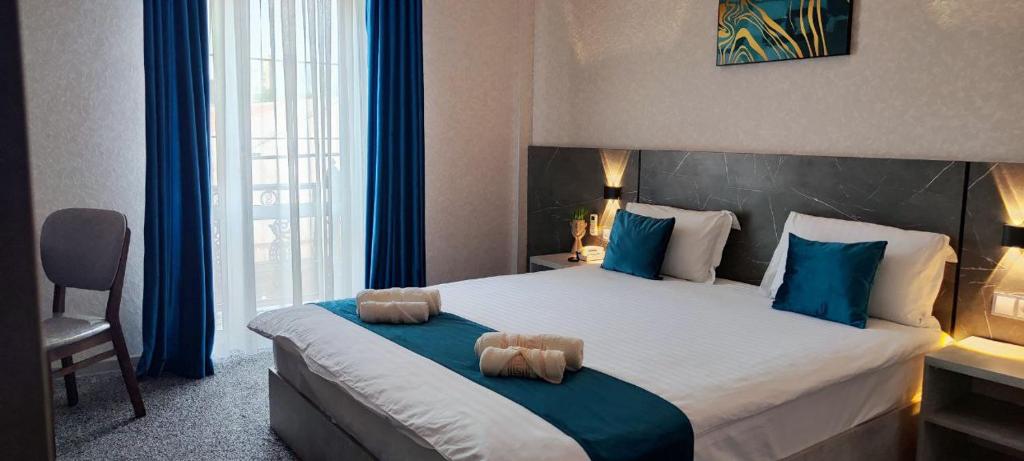een slaapkamer met een groot bed met blauwe kussens bij Boston Hotel in Yakkasaray
