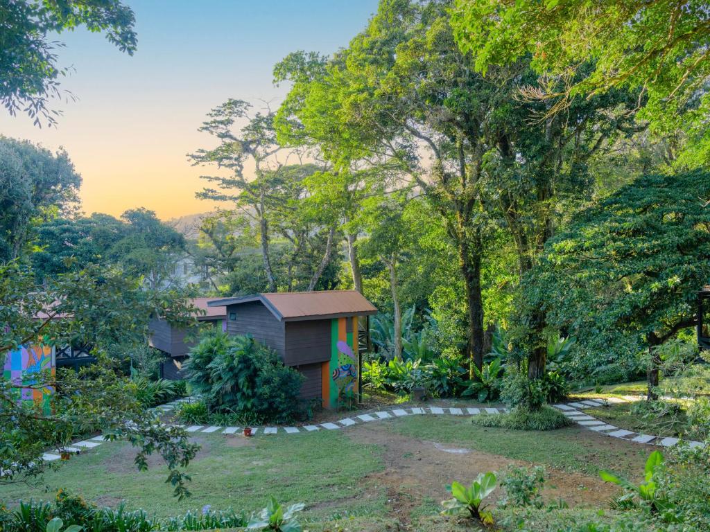 ein Haus inmitten eines Gartens in der Unterkunft Nido de Montaña in Alajuela