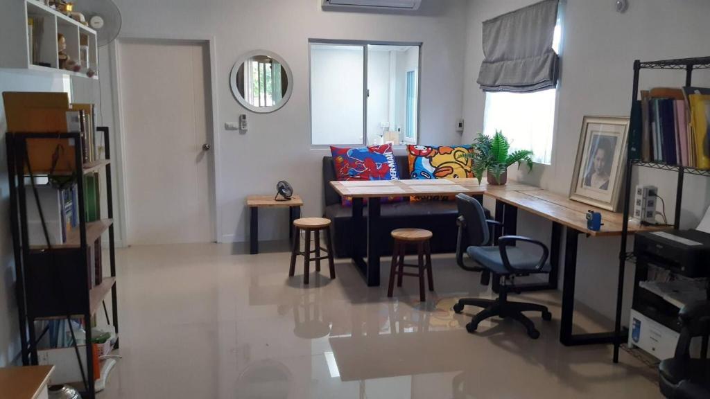 un salon avec une table, des chaises et un bureau dans l'établissement Cosy Preuksa House 120, à Ban Bang Yai