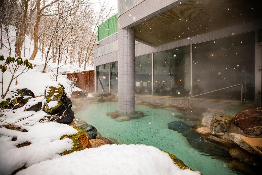 een gebouw met een hot tub in de sneeuw bij Otaru Asari Classe Hotel in Otaru