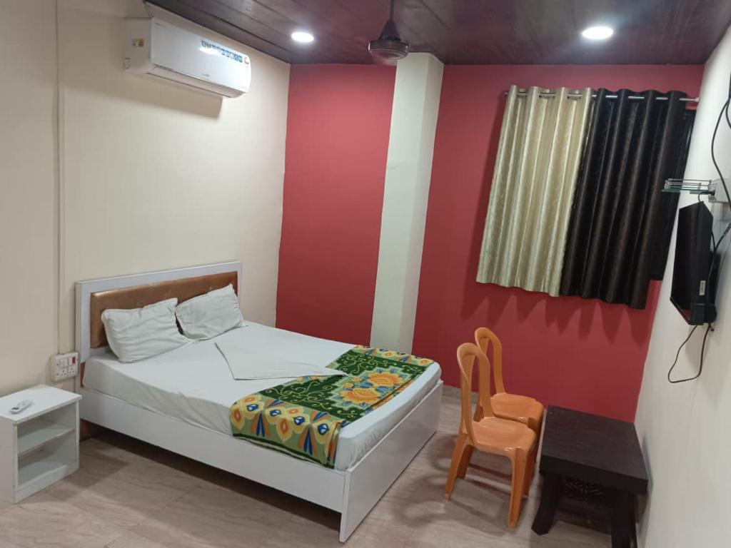 ein Schlafzimmer mit einem Bett, einem Tisch und einem Stuhl in der Unterkunft sai villa lodging and boarding in Virār