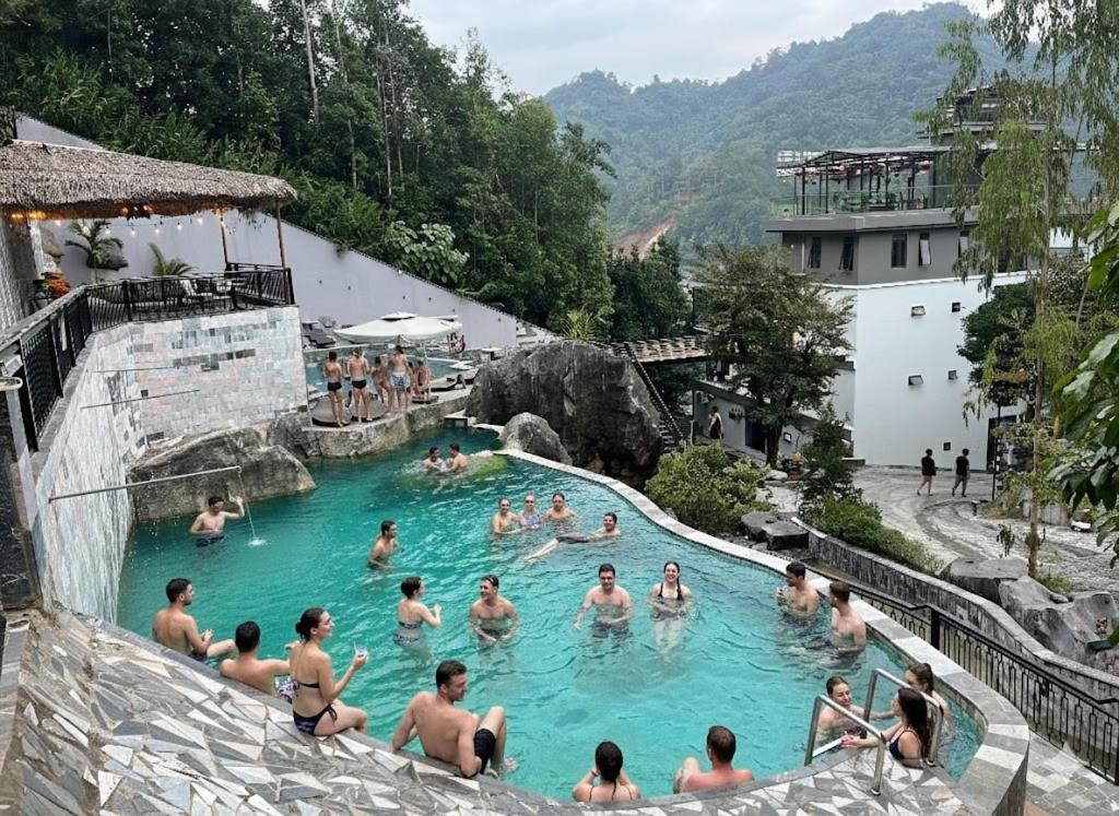 eine Gruppe von Menschen im Swimmingpool eines Resorts in der Unterkunft Lotus Hostel Ha Giang Loop in Ha Giang