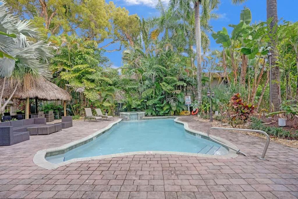 a swimming pool in the middle of a courtyard with trees at Tropical Oasis Studio w Pool in Fort Lauderdale