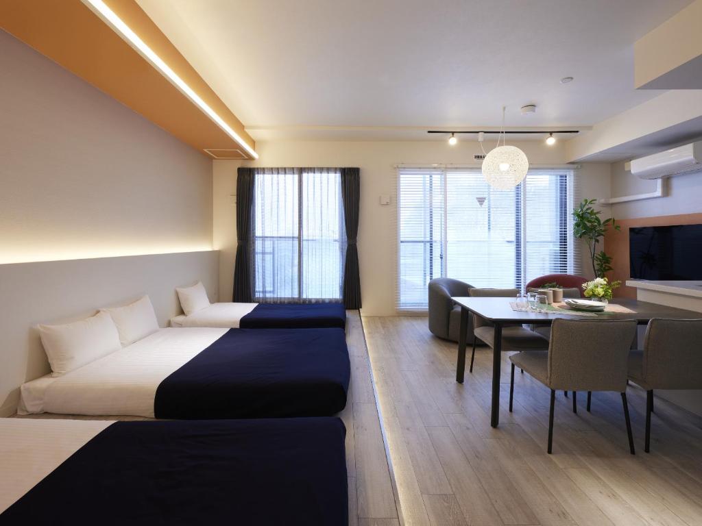 een hotelkamer met een bed en een eetkamer bij Minn Chitose in Chitose