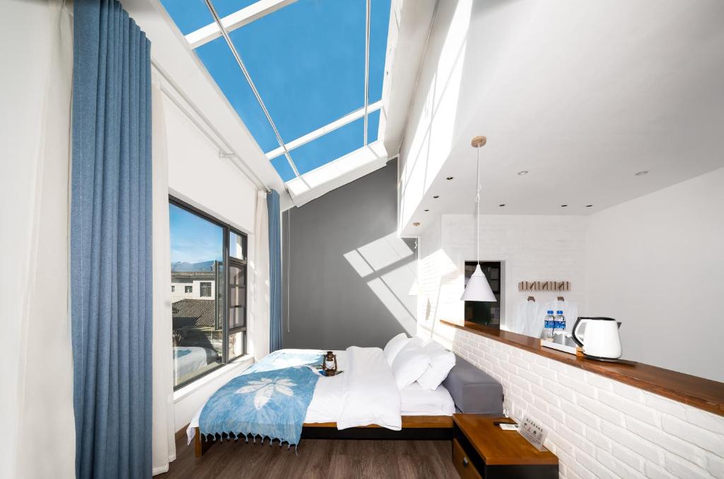 a bedroom with a bed and a large window at 叁三民宿 in Dali