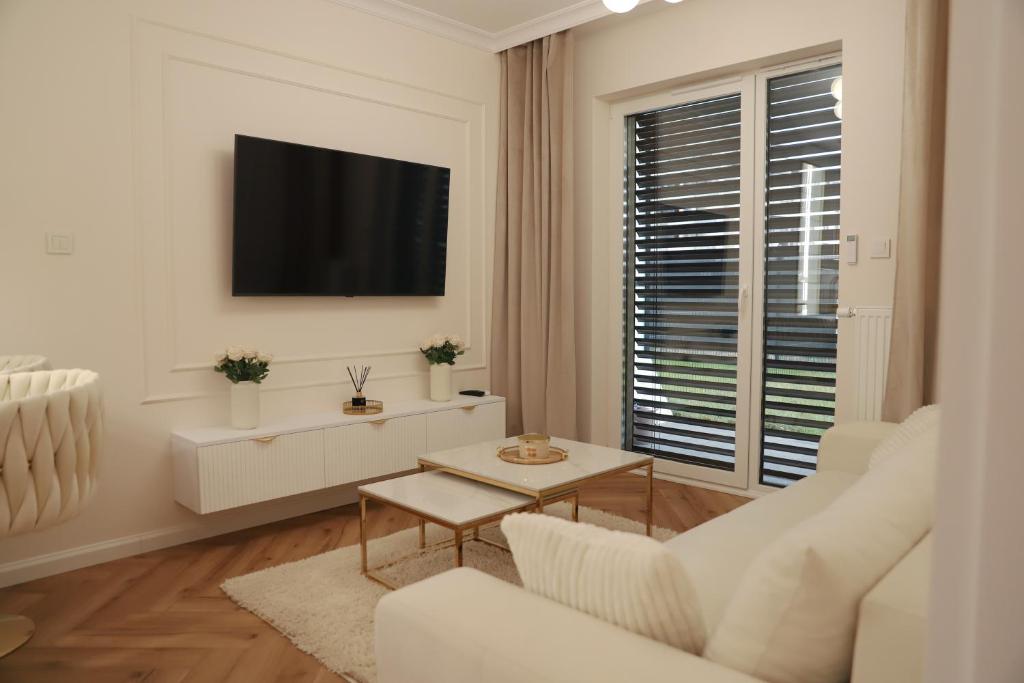 un soggiorno bianco con divano bianco e TV di Apartamenty Villa Piano a Ostrołęka