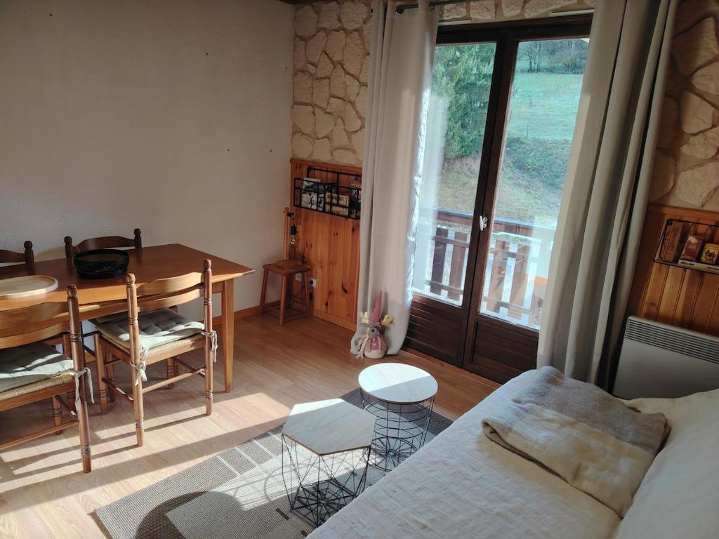 een woonkamer met een tafel en een bank en een tafel bij Appartement type chalet savoyard cosy in Aillon-le-Jeune