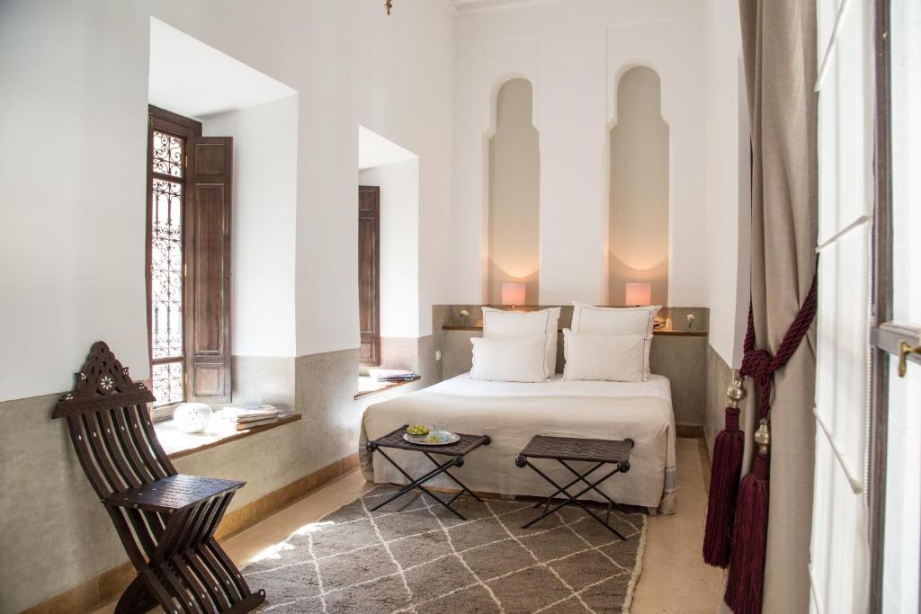 une chambre avec un lit et une chaise dans l'établissement Riad Olema et Spa, à Marrakech