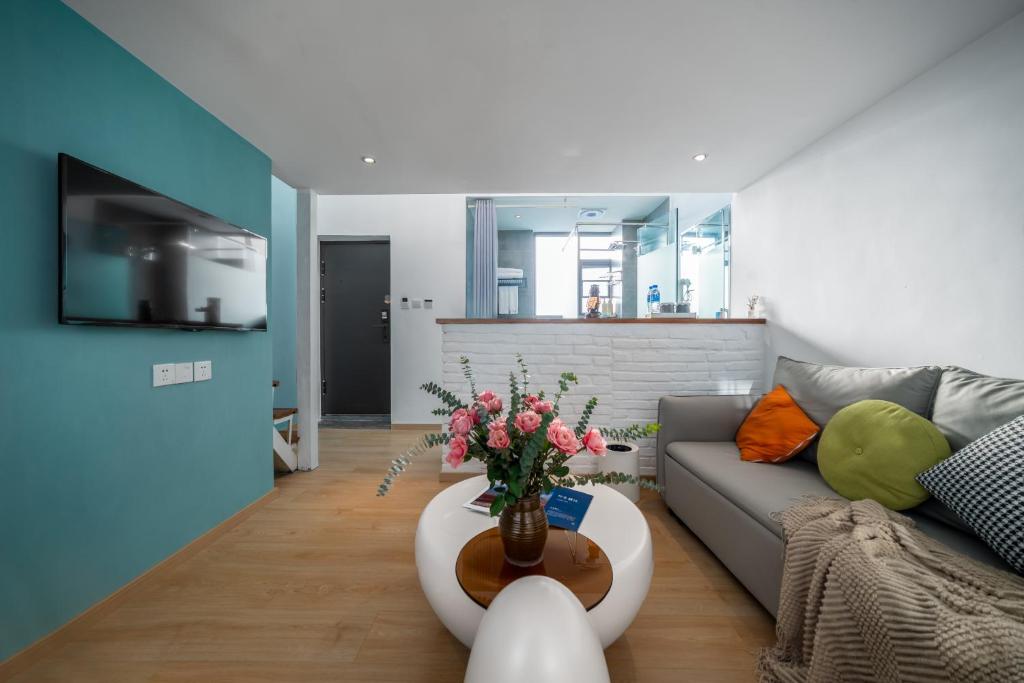 un salon avec un canapé et une table avec des fleurs dans l'établissement 叁三民宿, à Dali