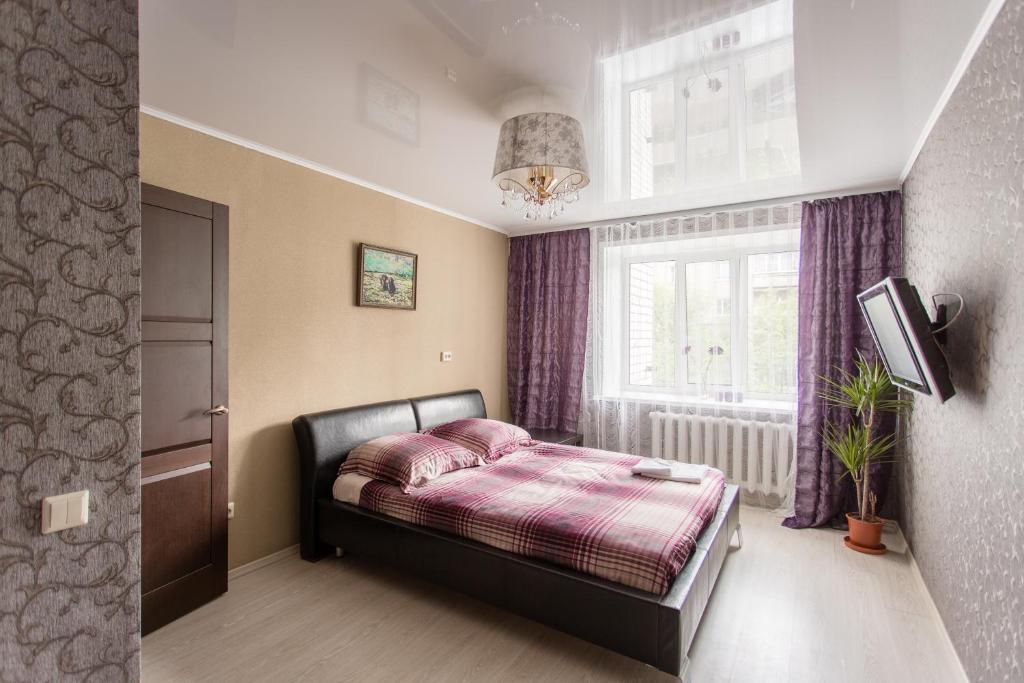 a small bedroom with a bed and a window at Apartment 2Pillows Vorovskogo in Vologda