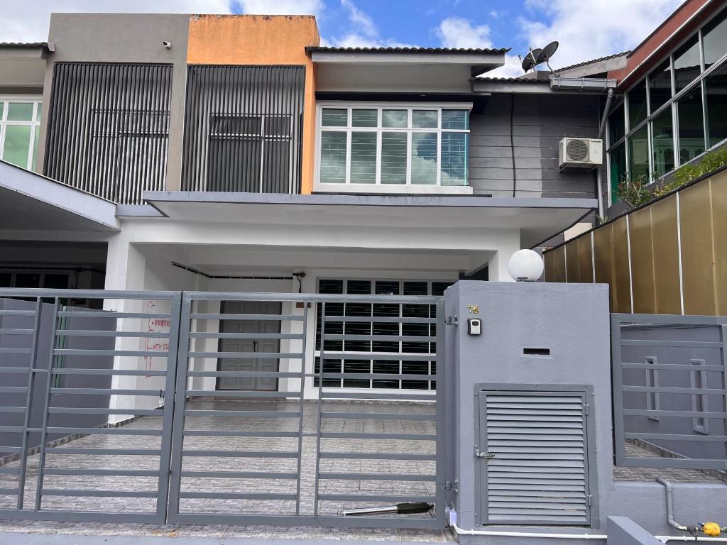 een huis met een poort en een koelkast ervoor bij Homestay 76 in Mersing