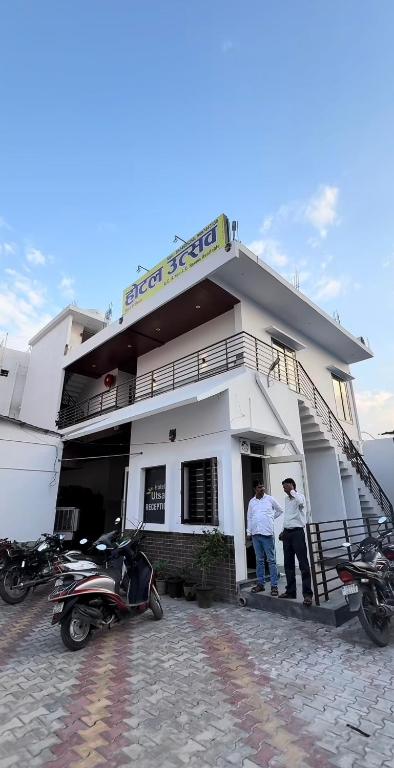 two men standing in the doorway of a building at Hotel Utsav in Khatīma