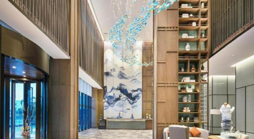 een lobby van een gebouw met een schilderij aan de muur bij Wanda JIN Baise in Qitang