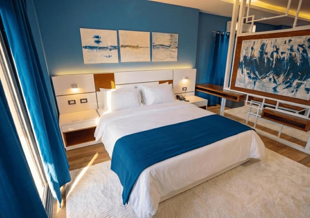 a bedroom with a large bed with blue walls at Travelholic New Cairo Residence in Cairo