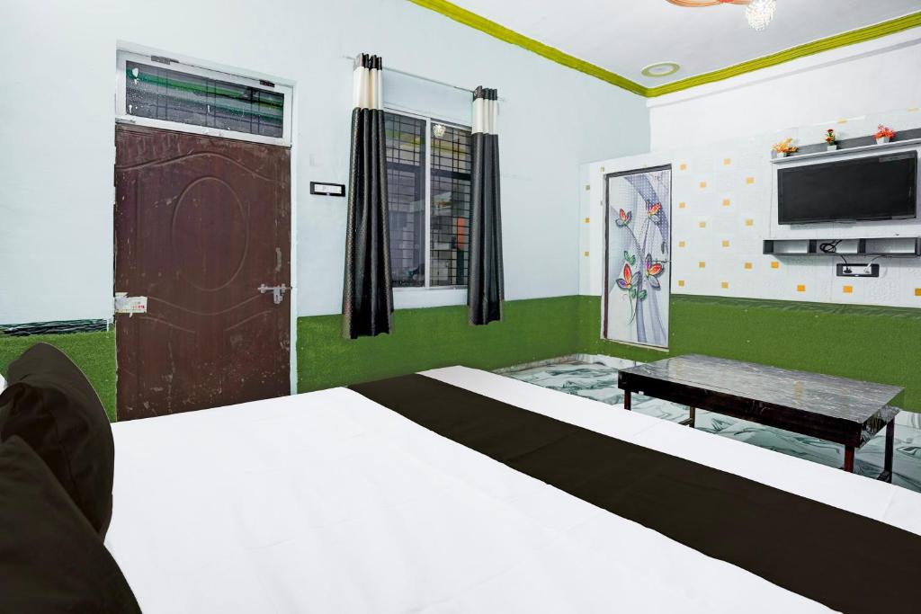 una camera da letto con un letto e una TV a schermo piatto di Hotel O by OYO J.B. HOTEL a Bewar