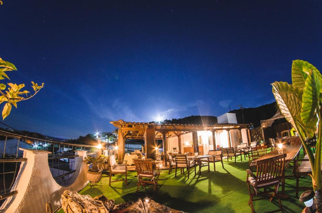 a patio with chairs and tables at night at Katerina apartments in Néos Pírgos