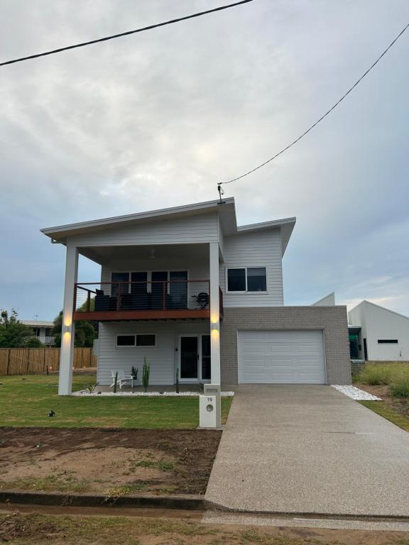 a large white house with a garage at Coastal Escape in North Coast