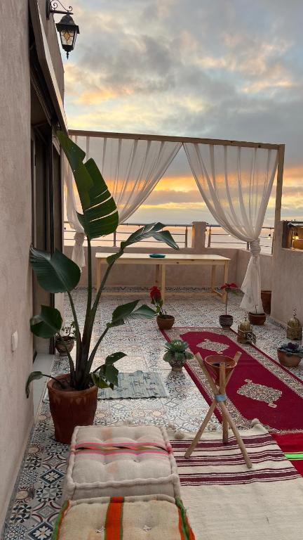 a patio with a table and a potted plant at Shams House in Imsouane