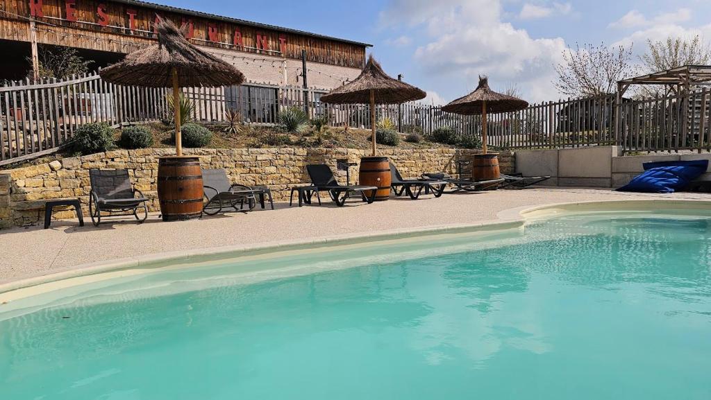 une piscine avec chaises et parasols à côté d'un bâtiment dans l'établissement L'Escale Occitane, à Alzonne