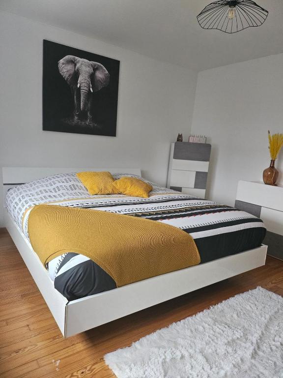 a bedroom with a bed with a black and yellow blanket at Welcome to Angèle 'Homes 2 in Niederbronn-les-Bains