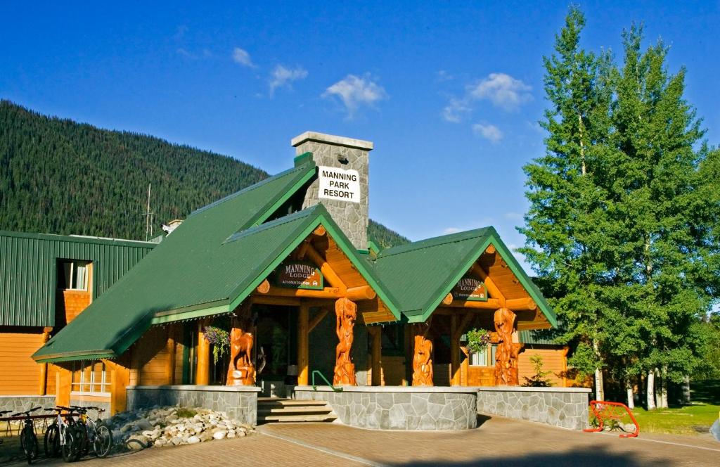 a log cabin with a green roof at Manning Park Resort in Manning Park